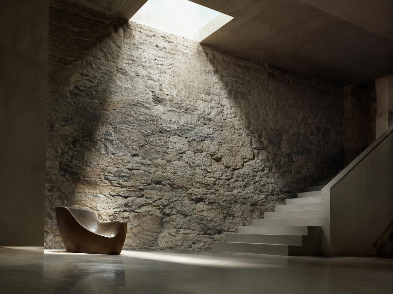 Skylit stone hall with a concrete stair